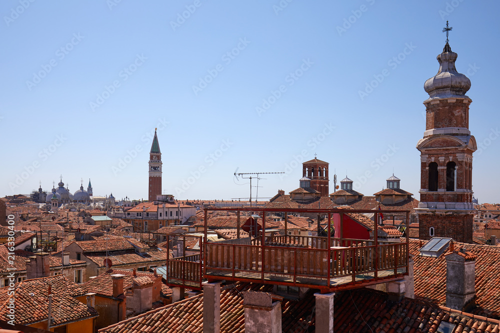 Venice roofs with typical altana balcony and San Marco bell tower in summer, Italy