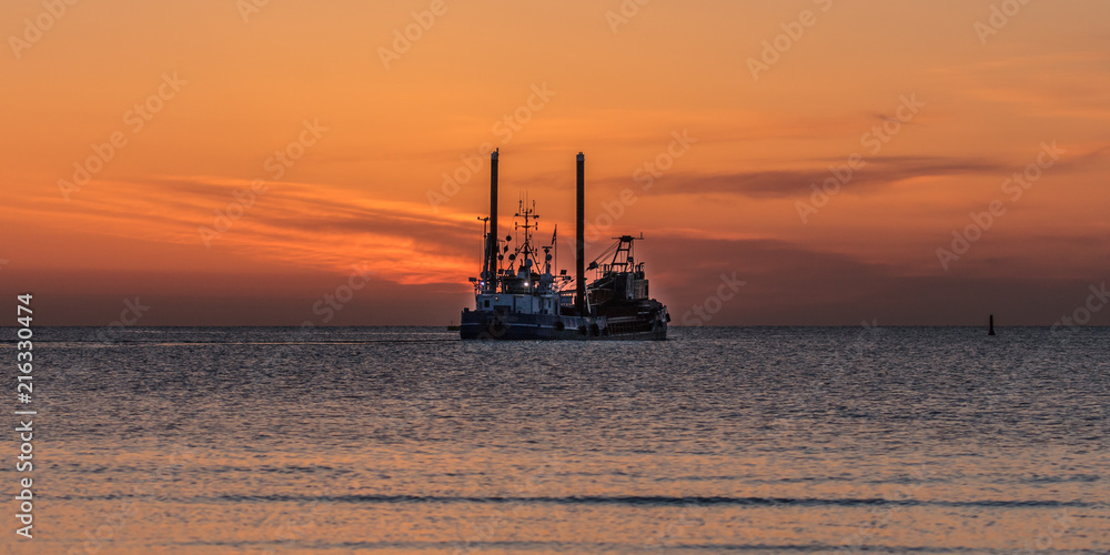 baggerschiff bei sonnenaufgang