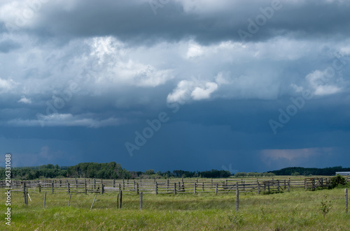 Wood Corral with approaching storm clouds, Saskatchewan, Canada.