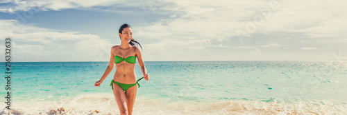 Vacation beach bikini happy woman running on blue ocean water background in tropical Caribbean travel destination panoramic banner. Summer lifestyle.