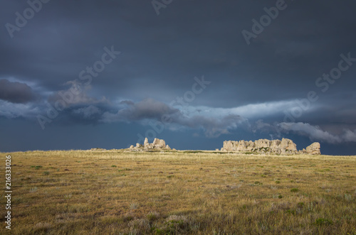A dark and stormy sky behind a rocky ridge on the North American prairie.