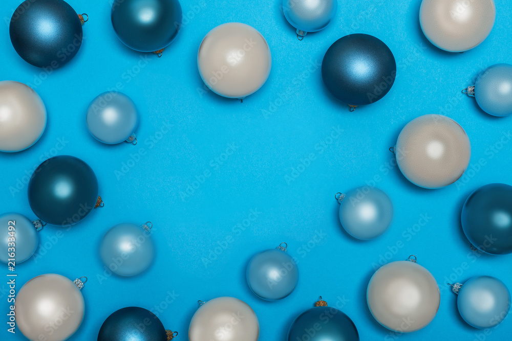 a view from above on New Year's and Christmas decorations, toys, Christmas balls. Christmas balls on a bright blue background in a frame with space for text. flat lay