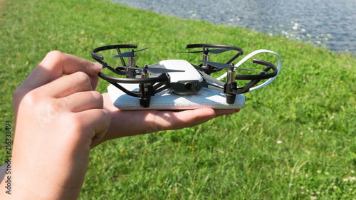 A teenager boy starts a quadrocopter from a smartphone and takes a nature shoot for his video blog. Flying robot drone. Robotics and programming. STEM education.