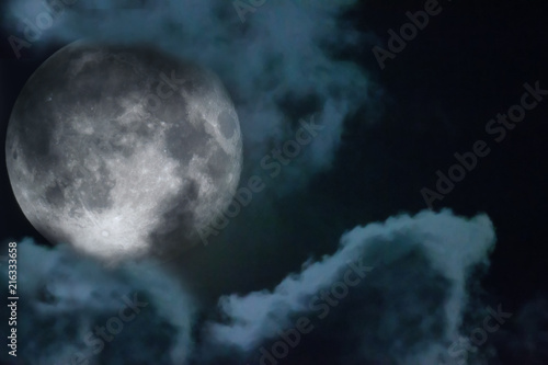 Halloween night sky with clouds and appearance of a full moon with craters close up