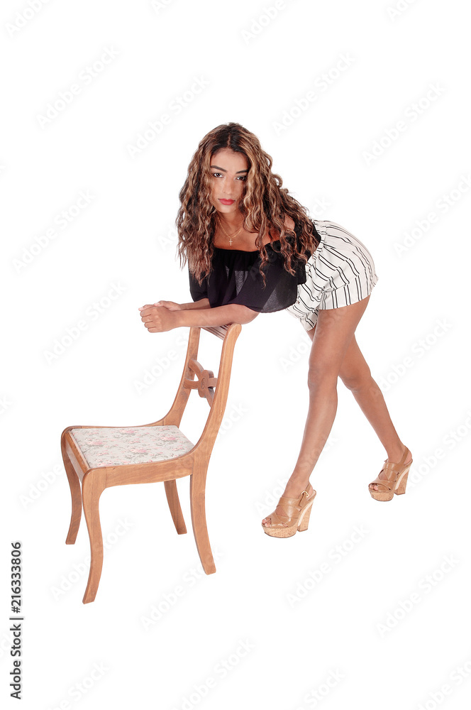 Lovely woman standing on old armchair Lovely woman standing on old armchair