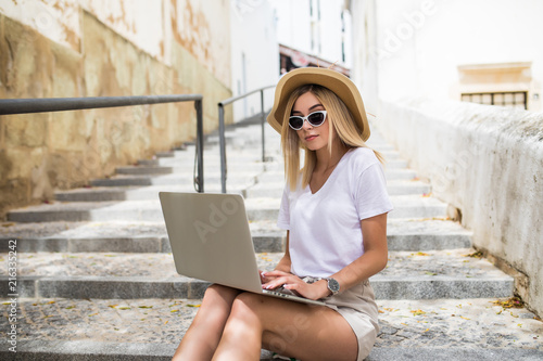 Young woman with laptop sitting on stairs © F8  \ Suport Ukraine