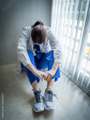 Tired doctor sitting alone in hospital floor