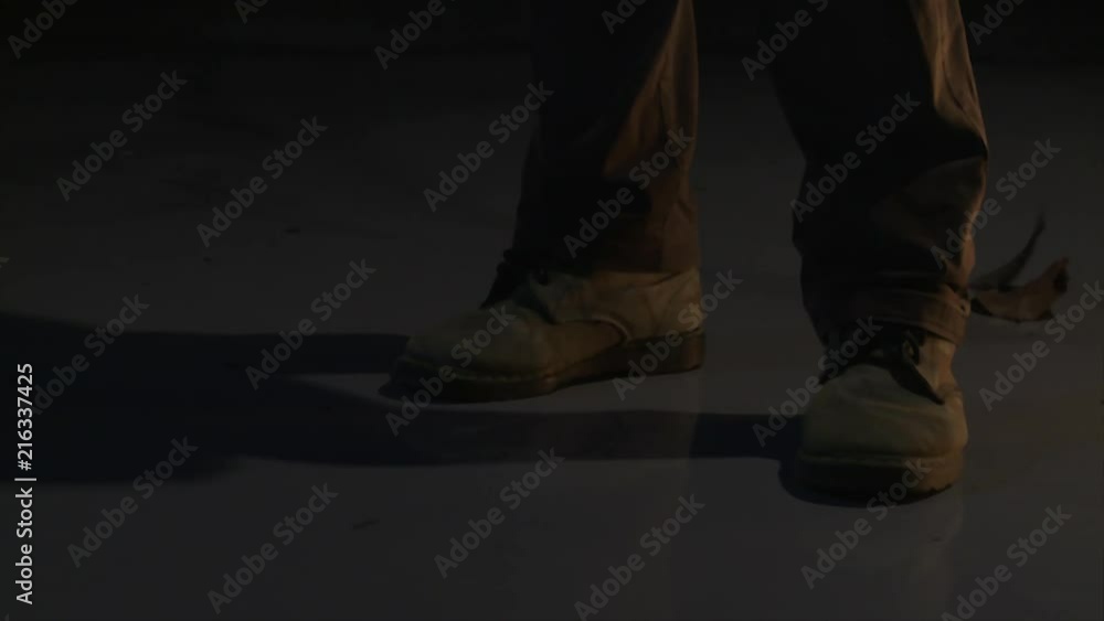 Man in the Dark with Boots Pick Up the Leaf after Wind Blow Man in the Dark with Boots Pick Up the Leaf after Wind Blow