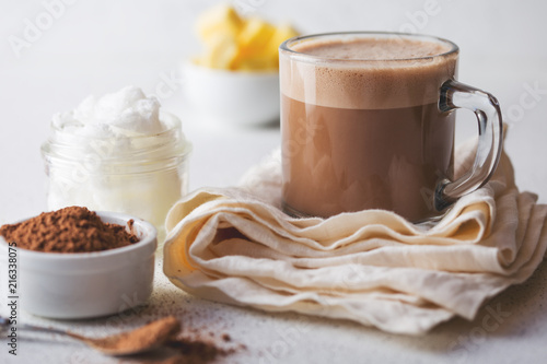 BULLETPROOF CACAO. Ketogenic keto diet hot drink. Cacao blended with coconut oil and butter. Cup of bulletproof cacao and ingredients on white background photo