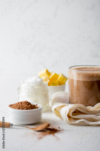 BULLETPROOF CACAO. Ketogenic keto diet hot drink. Cacao blended with coconut oil and butter. Cup of bulletproof cacao and ingredients on white background