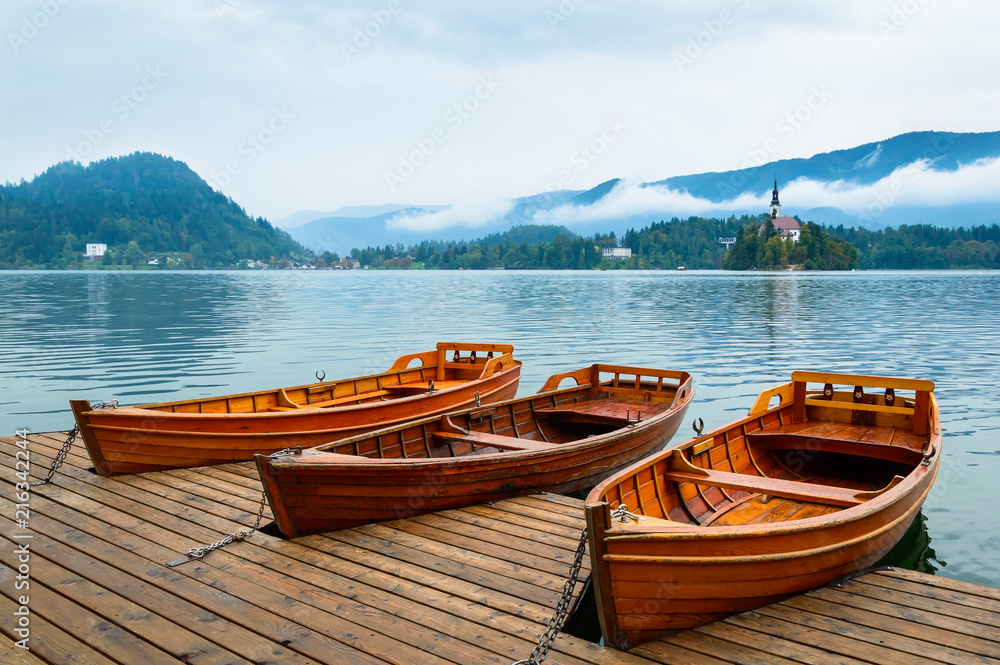 Boats on Bled Lake in Slovenia. Mountain lake with small island, and church.