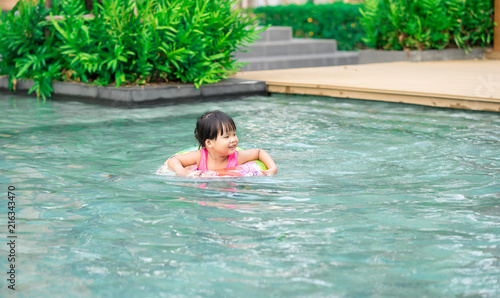 Little girl with rubber ring in swimming pool © domonite