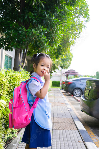little girl with backpack walking in car park ready back to school
