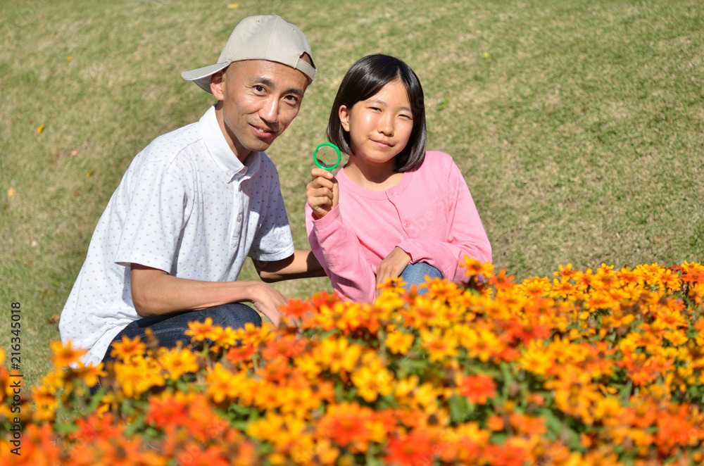 花を虫眼鏡で観察する親子 花を虫眼鏡で観察する親子