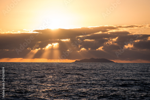 isola di gorgona al tramonto con raggi di luce photo