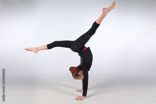 Female child gymnast performs a handstand splits