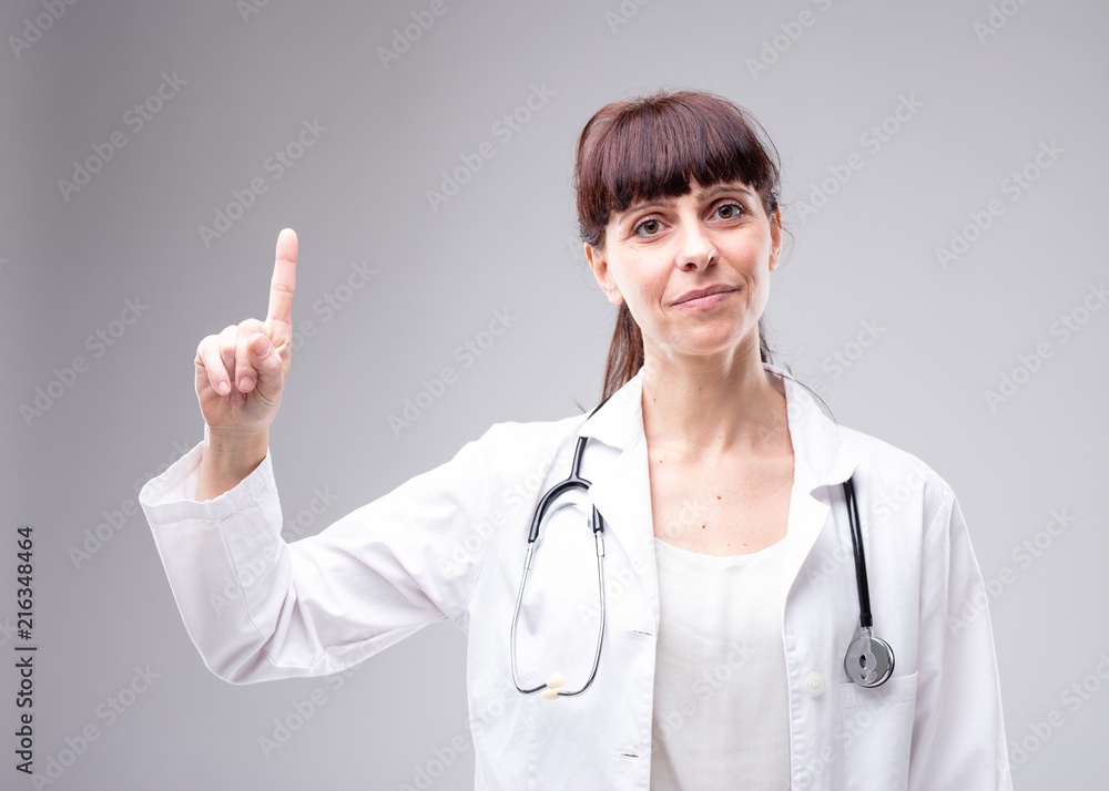 Smiling woman doctor holding up a finger Smiling woman doctor holding up a finger