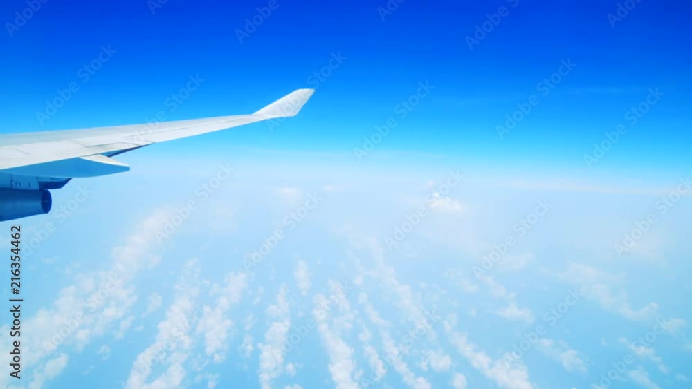 Bright blue sky and wing seen from inside an airplane Bright blue sky and wing seen from inside an airplane