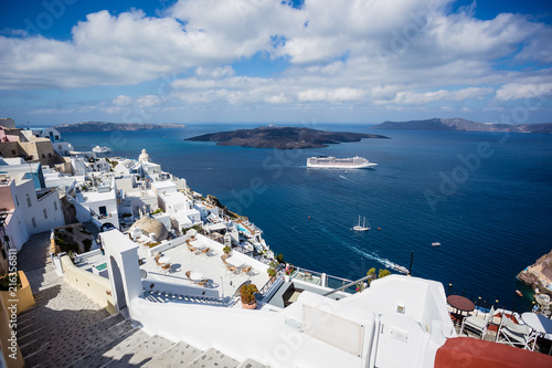 Gourgeous view from white walled town of Fira in Santorini, Greece, with ocean, cliffs and caldera of Santorini in the background.