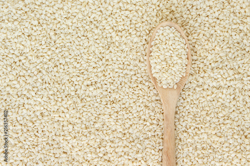 white sesame seeds in spoon on white backgroud