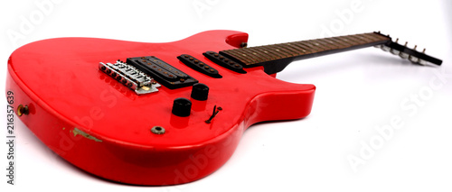 Red electric guitar with white backdrop.