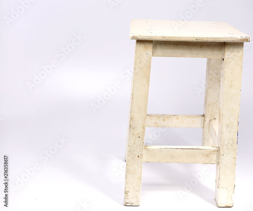 Wooden chair with white backdrop.