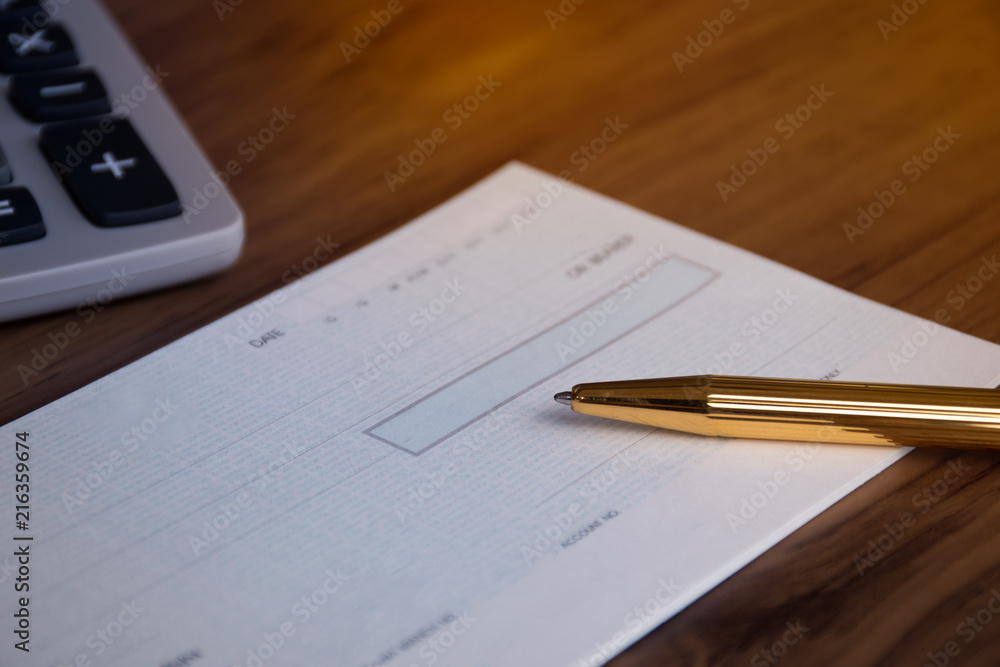 Mock up image of cheque book, pen and calculator on wooden background. Mock up image of cheque book, pen and calculator on wooden background.