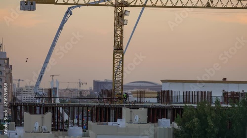 Doha, Qatar, 10 December 2016 - Construction on the building in Bin Omran area with workers operating a cement pump. photo