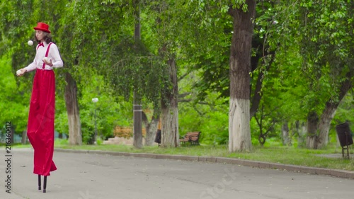 Comical mime walks on stilts and juggling