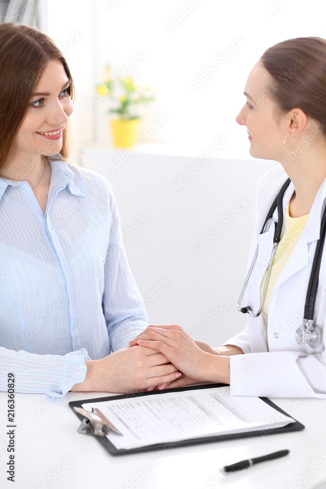 Doctor and patient sitting at the desk near window Doctor and patient sitting at the desk near window