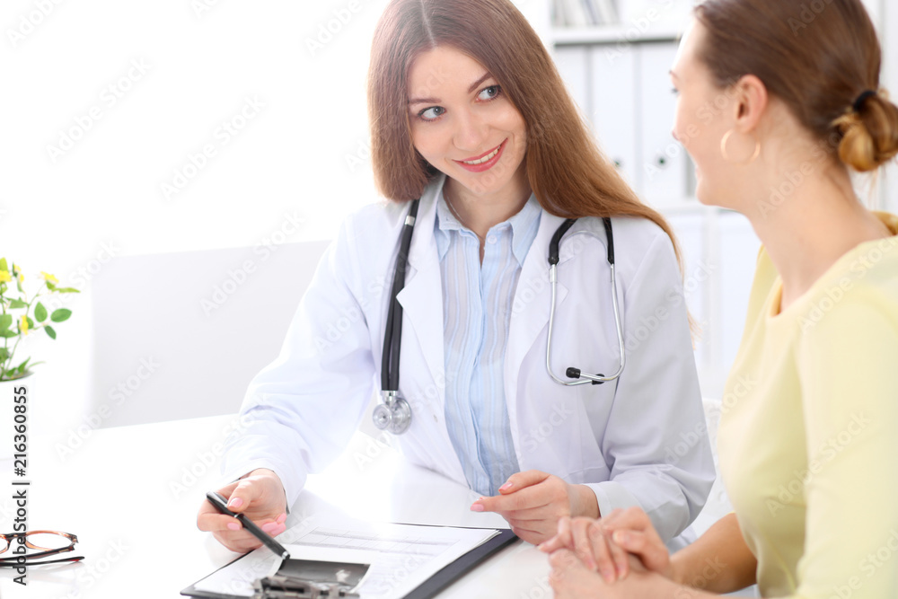 Doctor and patient sitting at the desk near window Doctor and patient sitting at the desk near window