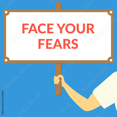 FACE YOUR FEARS. Hand holding wooden sign