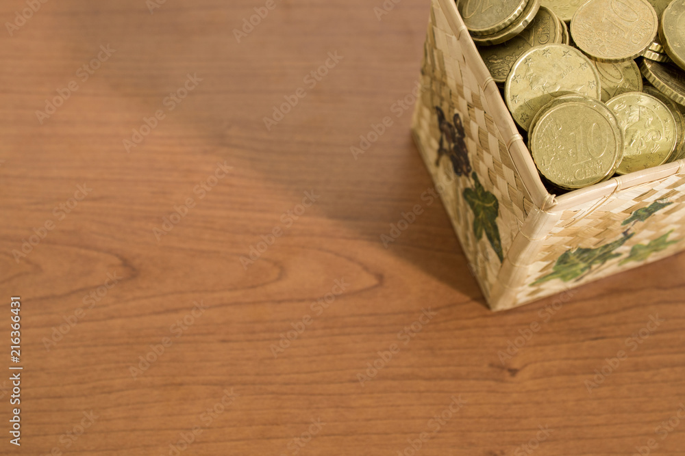 Fototapeta premium Box full of euro coins on a wood table