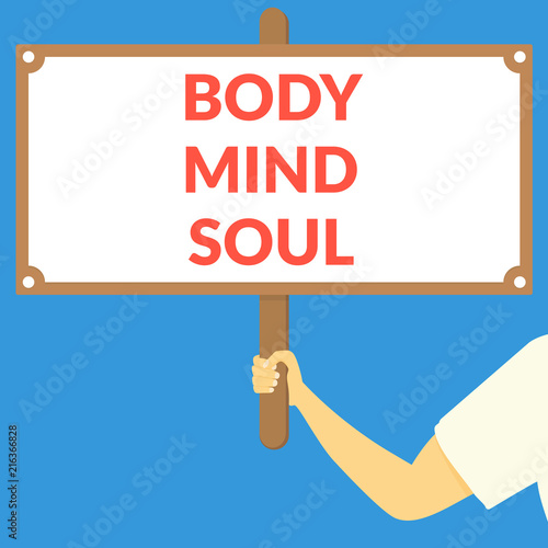 BODY MIND SOUL. Hand holding wooden sign