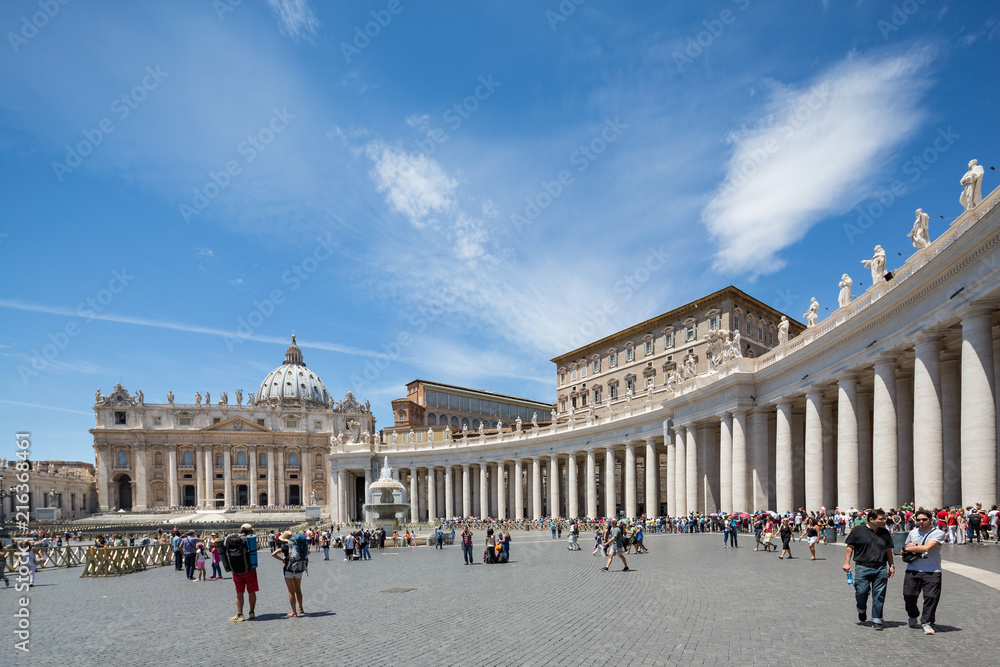 Obraz premium Statues on the colonnades and tourists in front of a fountain in St Peter's square