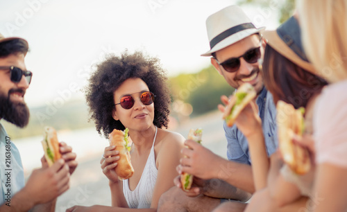 Group of friends eating sandwiches