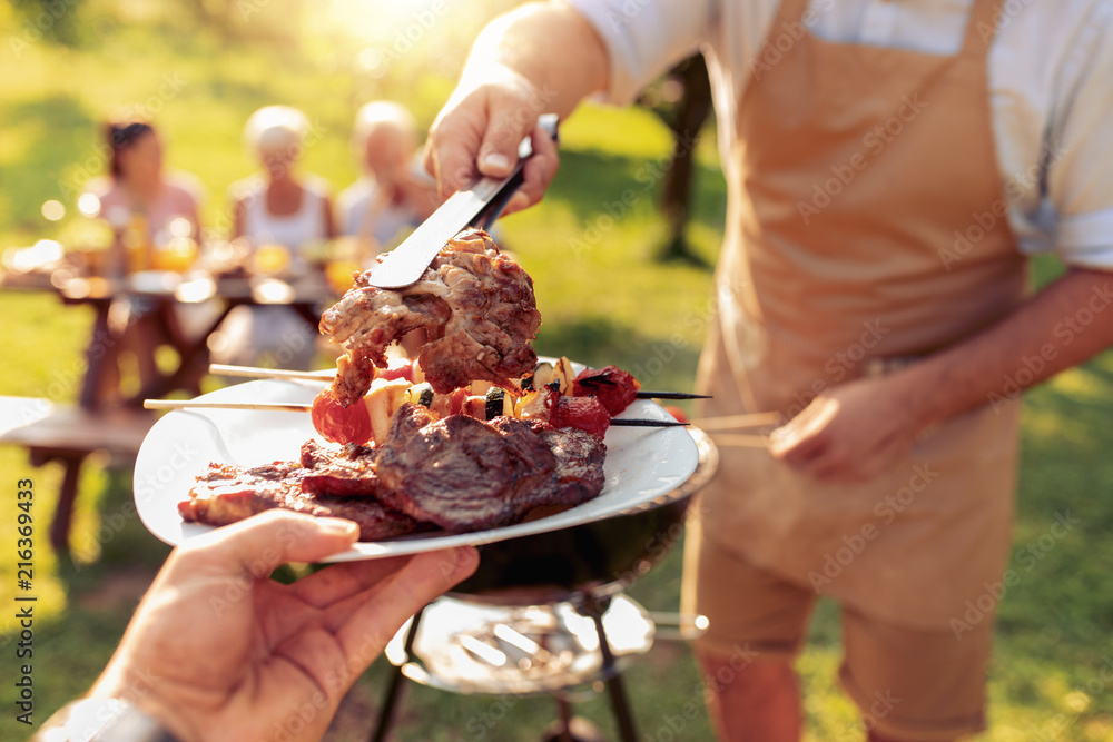 © ivanko80 - Family grilling meat on a barbecue