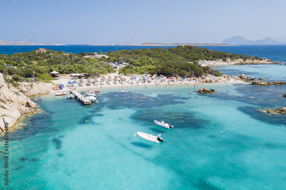 View from above, aerial view of an emerald and transparent Mediterranean sea with a white beach and some boats and yachts. Costa Smeralda, Sardinia, Italy