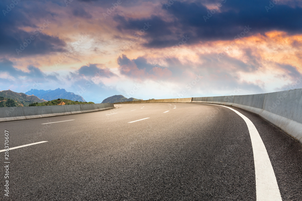 Naklejka premium Asphalt highway and mountain natural landscape at sunrise
