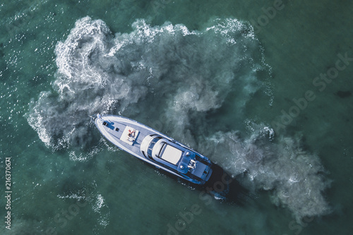 View from above, aerial view of a yacht sailing on an emerald and transparent Mediterranean sea. Emerald coast (Costa Smeralda), Sardinia, Italy.
