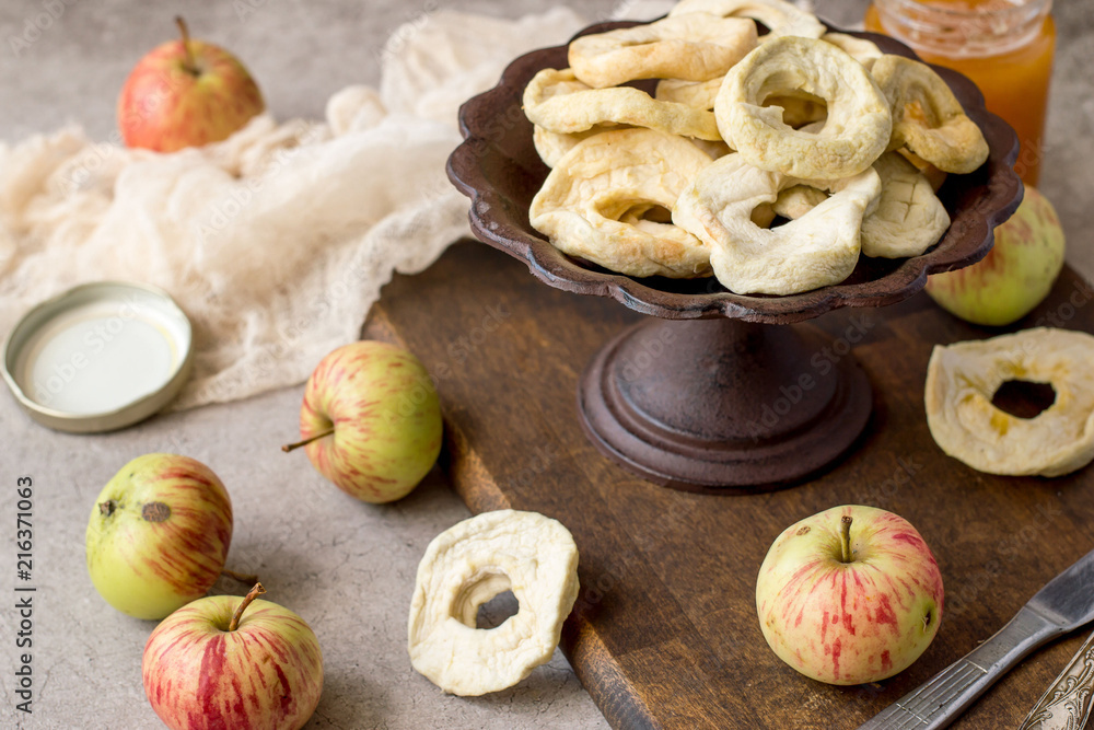 Dessert. Dried apple rings in a round old vase, next to fresh apples on a brown wooden board. Dessert. Dried apple rings in a round old vase, next to fresh apples on a brown wooden board.