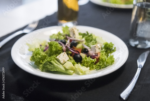 Caesar salad with chicken fillet and parmesan cheese, onion, olives, salad.