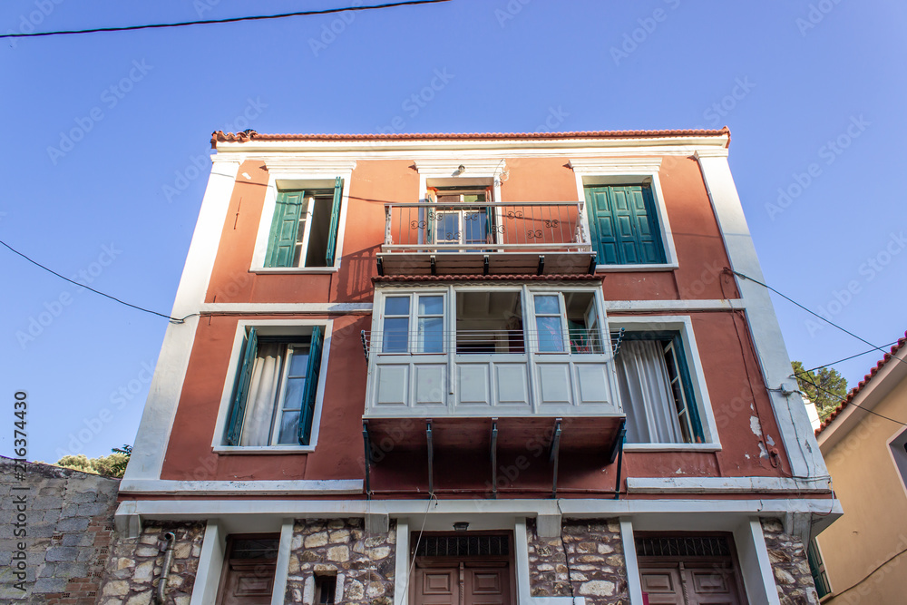 Bottom shot of perspective multi storey building orange colored facade at Lesvos in central part of region