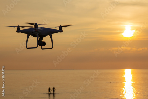 professional drone quad copter with digital camera at sunset ready to fly for surveillance. close-up of Rotor UAV. four blade propeller drone. silhouette copter on beautiful sunset.