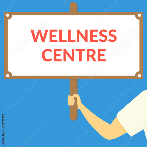 WELLNESS CENTRE. Hand holding wooden sign