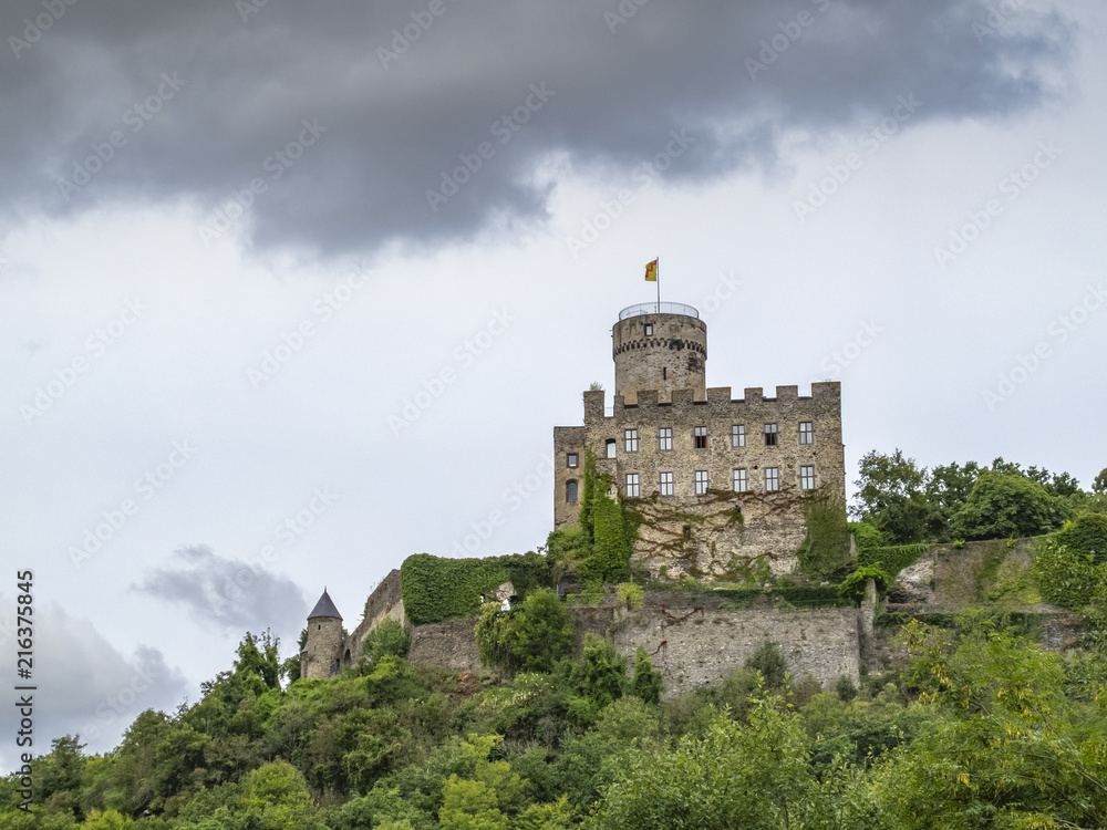 Dramatic picture of the rock Castle of Pyrmont in Germany against a moody September sky as seen from the main road below