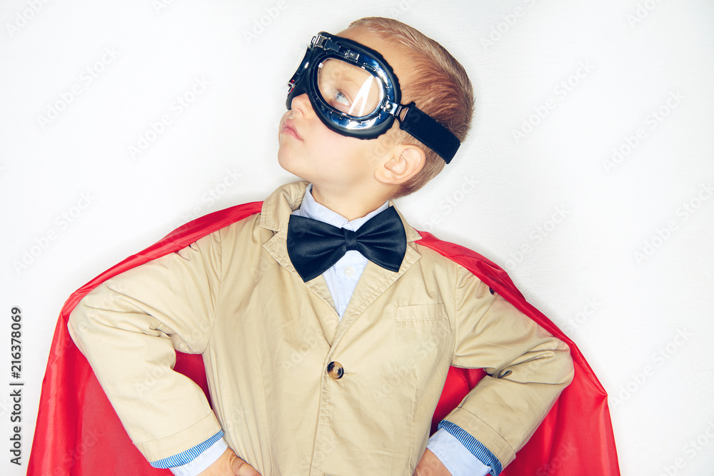 Cute little superhero boy looking up to the sky Cute little superhero boy looking up to the sky