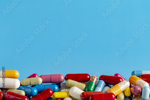 Heap of colorful drugs and pills on color background