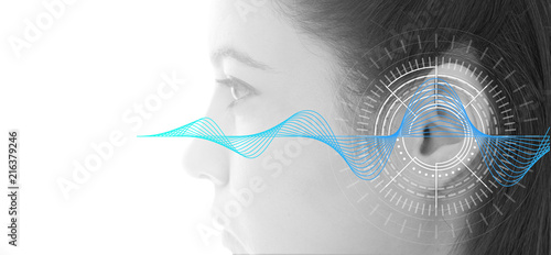 Hearing test showing ear of young woman with sound waves simulation technology photo