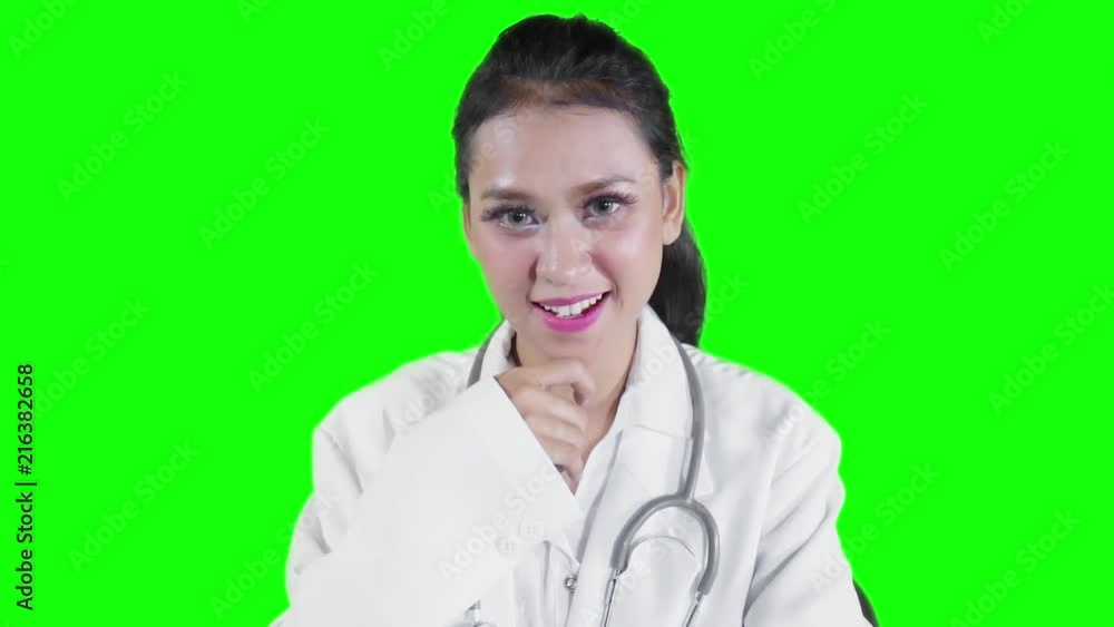 Slow motion of young female doctor smiling at the camera with green screen background Slow motion of young female doctor smiling at the camera with green screen background